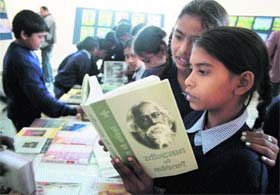 Students of Vasudhaiv Katubankum School, Rajiv Nagar, go through books during the inauguration of a childrens painting, craft and book exhibition organised at the Kala Kendra in Jammu on Tuesday