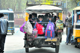 An overloaded auto-rickshaw ferries children to school in Ludhiana. 