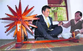 Former Japanese Prime Minister Yasuo Fukuda tries his hand at a spinning wheel during his visit to Sabarmati Gandhi Ashram in Ahmedabad on Tuesday