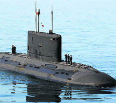 Iranian military personnel hoist their national flag on a submarine in the Strait of Hormuz. 