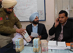 Bathinda DC KK Yadav and SSP Sukhchain Singh Gill with the currency notes seized during checking at Doomwali near Haryana border on Wednesday