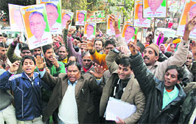 Supporters of former Congress minister Sadhuram hold a demonstration to demand party ticket for him at the state Congress headquarters in Dehradun on Thursday.