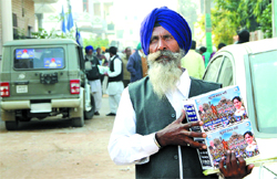 A BSP supporter carries a box of CDs in Jalandhar.