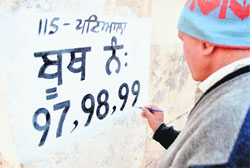 An electoral official marks a polling booth in Patiala. 