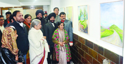 Laxmi Kanta Chawla takes a look at paintings during an exhibition 'In the Lap of Nature' at KT Kala Art Gallery in Amritsar. 