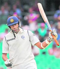 R Ashwin raises his bat to celebrate his half-century in Sydney on Friday. 