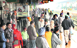 Passengers seen waiting for a train at the Jalandhar railway station on Friday