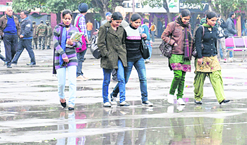 Shoppers walk in the open even as it drizzles at Sector 17, Chandigarh, on Saturday.