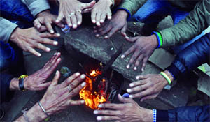 Labourers warm their hands around a bonfire on a cold Saturday in New Delhi. 