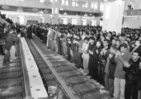 People pray in a mosque over the flag-draped caskets of some of the 26 persons killed in Fidays suicide bomb attack in Damascus, on Saturday.