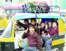 Unmindful of the danger they have been exposed to, school children are all smiles on their way to school in an overcrowded auto-rickshaw in Amritsar.