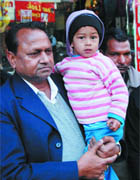 The president of Sahara Jan Sewa, Vijay Goyal, holds a two and a half-years-old boy, who was found abandoned at the railway station in Bathinda 