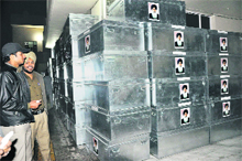A flying squad on election duty inspects trunks containing utensils with photographs of Punjab Chief Minister Parkash Singh Badal at Industrial Area, Phase VIII, Mohali, on Sunday evening.