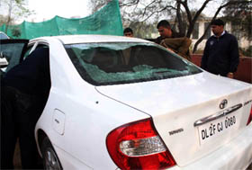 Policemen inspect the car damaged in firing at DLF-2 in Gurgaon. A case under Section 307 has been registered.