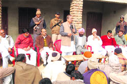 Former minister Jagdish Nehra addresses a meeting in a village in Sirsa on Sunday as Sirsa district Congress president Malkiat Singh Khosa (second from right) looks on.