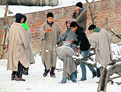 Boys throw snowballs at one another after a snowfall in Srinagar on Sunday. Temperatures in Kashmir valley dipped even as authorities struggled to restore power supply and essential services in the snow-hit areas