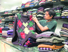 A salesman displayes woollens at a shop in Ghumar Mandi, Ludhiana. 