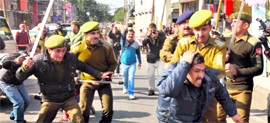 A man ducks for cover after policemen resort to cane-charge during a march by daily wagers working with the Power Development Department in Jammu on Monday.