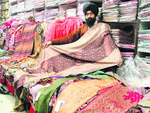 A salesman shows shawls at a store in Ludhiana.