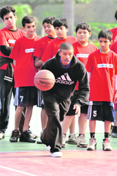 Former NBA player Muggsy Bogues (C) gives tips to school children in New Delhi on Monday. Bogues at 53 is the shortest player ever to have featured in