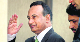 Husain Haqqani salutes to media as he arrives to appear before a judicial panel in Islamabad on Monday.