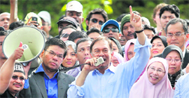 Malaysias Opposition leader Anwar Ibrahim (C) with his supporters while flanked by his wife Wan Azizah Wan Ismail in Kuala Lumpur on Monday.