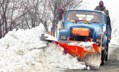 A truck clears snow on the Srinagar-Jammu highway near Lower Munda, 85 km south of Srinagar. The authorities have sounded an avalanche alert in the upper reaches of the Kashmir valley