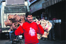 A man carries kangris for sale at the General Bus Stand in Jammu.