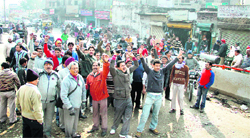 Shopkeepers block traffic on Domoria ROB in Jalandhar on Tuesday.
