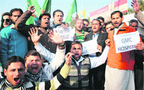 Activists of the PDP stage a protest against the GMCH administration for increasing OPD and emergency fee at the hospital in Jammu on Wednesday