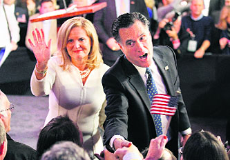 Republican presidential candidate and former Massachusetts Governor Mitt Romney shakes hands with supporters as his wife Ann waves after he spoke at his New Hampshire primary night rally in Manchester.
