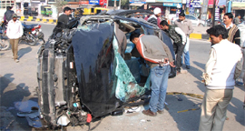 People examine the mangled remains of the car that hit the Bibiwala Chowk in Bathinda on Thursday.