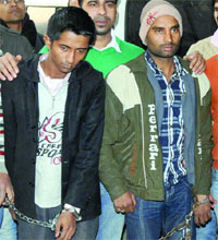 Two persons arrested in connection with the seizure of counterfeit notes in custudy of the Delhi police in New Delhi on Friday.
