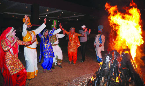 Punjabi folk artistes perform around a bonfire to celebrate Lohri at the Hotel Lalit in New Delhi on Friday
