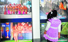 A girl looks at photographs at an exhibition organised by the state Tourism Department at Kala Kendra in Jammu on Friday.
