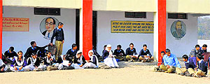 Students of a government school attend classes in the open on a sunny day in Jammu