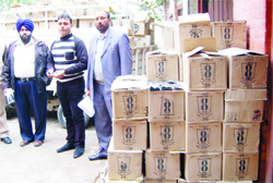 Officials with the liquor boxes seized in Amritsar 