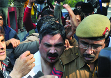 Security personnel take away Kamran Siddiqui who threw black ink on yoga guru Baba Ramdev after a press conference in New Delhi on Saturday.
