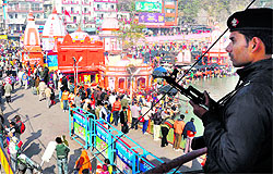 A commando monitors the Har-ki-Pauri mela zone on the occasion of Makar Sankranti in Haridwar on Saturday