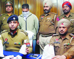 Police officers with the contraband seized in Jalandhar on Saturday. 