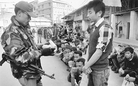 A Manipur Police commando verifies credentials of youngsters during a combing operation ahead of the state Assembly polls in Imphal on Saturday.