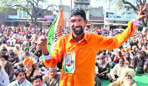 A Congress supporter holds a party flag at an election rally in Samana on Saturday. 