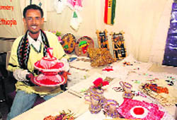 An Ethopian craftsperson showcases a medley of bead necklaces, Zulu love girdles, ethnic love letter pendants, leg-ring bangle and ethnic silverware, in New Delhi 