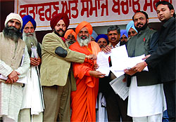 Baba Balbir Singh Seechewal receives the oath to eradicate pollution signed by four candidates for the Bathinda (Urban) Assembly seat, at the Teachers Home in Bathinda on Sunday