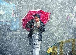 A girl braves the elements during a snowfall in Shimla on Sunday