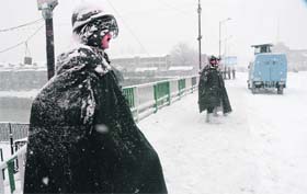CRPF jawans stand guard amid heavy snowfall in Srinagar on Sunday