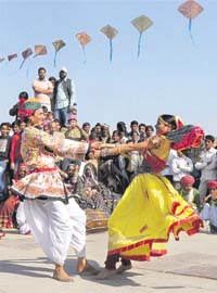 Folk artistes play a rural game during the Kite Festival on the occasion of Makar Sankranti in Jaipur