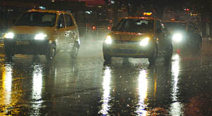 Vehicles move in rain in New Delhi on Monday. 