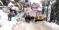A snow cutter clears a road at Lakkar Bazar in Shimla