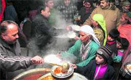 Stranded passengers take food distributed free of cost at a community kitchen organised by the state goverment at a bus stand in Jammu.